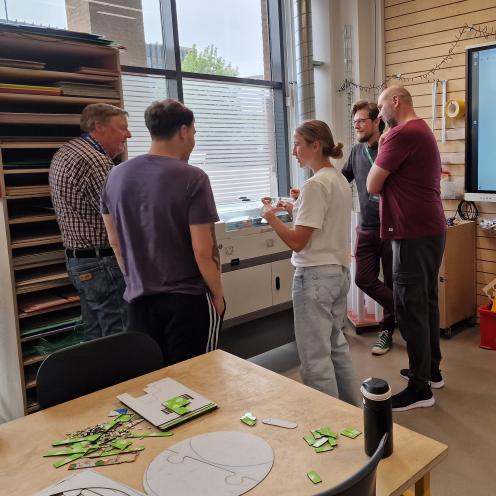 Folk står rundt om en lasercutter